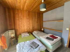 two beds in a room with wooden walls at CASA-Salon Bocca di Rosa suite pour 6 personnes in Molines-en-Queyras