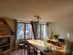 a dining room with a table and a fireplace at CASA-Salon Bocca di Rosa suite pour 6 personnes in Molines-en-Queyras