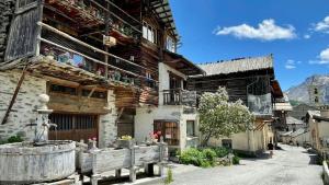 an old building with a barrel in front of it at CASA-Salon Bocca di Rosa suite pour 6 personnes in Molines-en-Queyras +39 photos