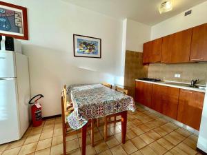 une petite cuisine avec une table et un réfrigérateur dans l'établissement Flat with excellent location, à Porto Santa Margherita 12 autres photos