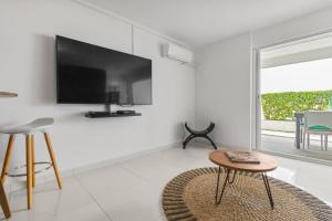 a living room with a tv and a table at Marigot Bay in Saint Martin