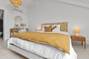 MarigotにあるAppartement Reflets Marinsの金色の毛布が掛けられた大きなベッドのある白い寝室