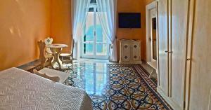 a bedroom with a bed and a table and a television at villa verde sul mare in Vietri sul Mare