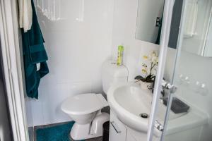 een witte badkamer met een toilet en een wastafel bij Cozy City House in the Heart of Paddington in Sydney