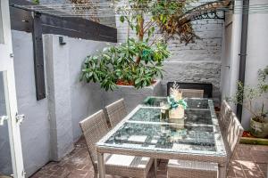 een patio met een tafel met stoelen en planten bij Cozy City House in the Heart of Paddington in Sydney +9 foto's