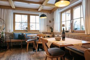 a restaurant with wooden tables and chairs and windows at Fürmesli Appartements in Lech am Arlberg