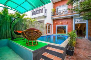 a house with a swimming pool with a chair next to it at Angkor Rithy Residences in Siem Reap