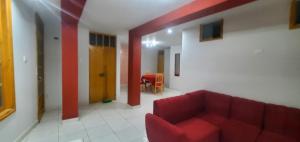 a living room with a red couch in a room at Departamento jaspe in Cajamarca +3 photos