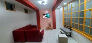 a living room with a red couch and a window at Departamento jaspe in Cajamarca