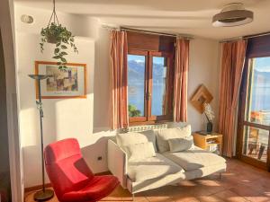 un soggiorno con un divano e una sedia rossa di Residenza Verde Lago a Stresa