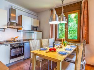 a kitchen with a wooden table with chairs and a dining room at Residenza Verde Lago in Stresa