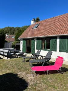 a group of picnic tables and chairs in front of a building at Maison Duinendaele 101 - De Panne in De Panne