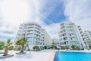 an image of two apartment buildings with a swimming pool at Scandic Resort Hurghada in Hurghada