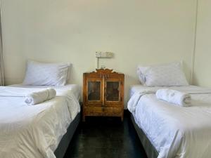 due letti uno accanto all'altro in una stanza di Cozy Twin Bedroom Homestay in Shared Bungalow SS2 PJ a Petaling Jaya