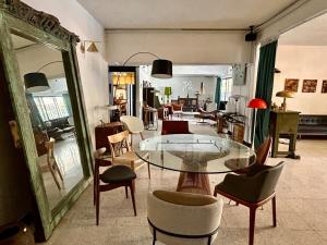 un soggiorno con tavolo e sedie in vetro di Cozy Twin Bedroom Homestay in Shared Bungalow SS2 PJ a Petaling Jaya