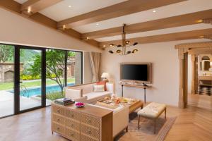 a living room with a couch and a tv at Taj Aravali Resort & Spa Udaipur in Udaipur
