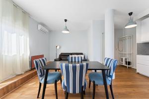 a dining room with a black table and blue chairs at GuestReady – Urban comfort in Vila Nova de Gaia in Vila Nova de Gaia