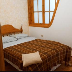 ein Schlafzimmer mit einem Bett mit einer Decke und einem Spiegel in der Unterkunft Departamento LUXOR in Cajamarca