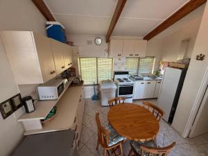 a small kitchen with a table and a refrigerator at Shelly Villa in Shelly Beach