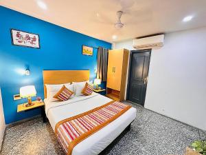 a bedroom with a large bed with a blue wall at Qotel Comfort Golden Saffron Punjabi Bagh in New Delhi