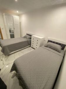 1 dormitorio con 2 camas, tocador y espejo en Chambre Torrevieja, en Torrevieja