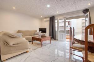 una sala de estar con un sofá y una mesa en Chambre Torrevieja, en Torrevieja