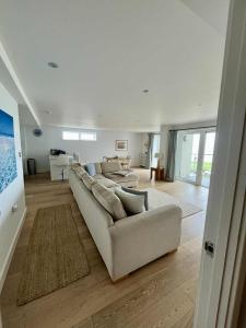 Una sala de estar blanca con un sofá y una mesa. en 6 Ocean Gate apartment, en Newquay