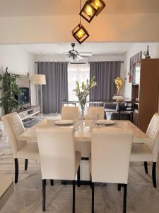 ein Esszimmer mit einem Tisch und weißen Stühlen in der Unterkunft SEA LA VIE @ LAGUNA CONDO RESORT in Port Dickson