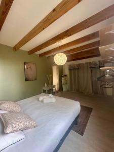 a bedroom with a large white bed in a room at Chalet de Russac - 6 personnes - Jardin clôturé avec terrasse aménagée in Turenne +25 photos