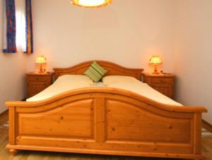 1 cama de madera en un dormitorio con 2 mesitas de noche en Panoramablick Ferienwohnung Schiestl, en Brandberg