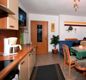 a kitchen with a table and a living room at Panoramablick Ferienwohnung Schiestl in Brandberg