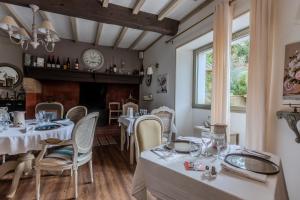 a dining room with tables and chairs and a fireplace at Maison Loustalet in Arzacq-Arraziguet