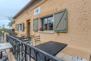a building with a table and chairs on a balcony at Maison Loustalet in Arzacq-Arraziguet