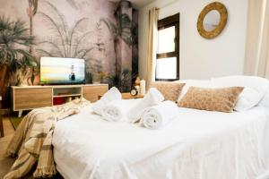 a bedroom with a white bed with towels on it at Villa Forest Ideal Familias Casco Histórico Balcón in Zaragoza