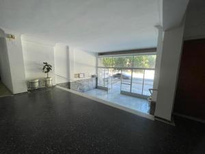 an empty room with a large window and a plant at Maison De La Mer in Isthmia