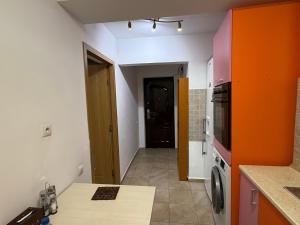 ブカレストにあるCazare Soseaua Oltenitei Bucurestiのオレンジ色の壁のキッチンとコンロのあるキッチン