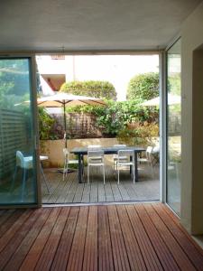 Spacious cocoon with nice garden close to the sea في ساناري سور مير: فناء مع طاولة وكراسي ومظلة