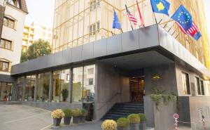 a building with two flags on top of it at Hotel Afa in Pristina