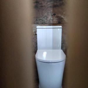 a bathroom with a white toilet in a room at La Chambre Du Village  +2 photos