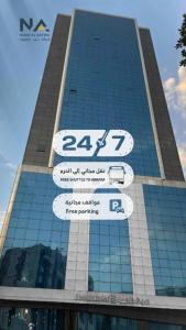 a tall building with signs in front of it at فندق الأصالة البكية توصيل مجاني الى الحرم - ALAsalah ALBakkiya Hotel Free Shuttel Service in Al Masfalah
