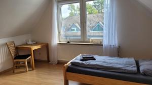 a bedroom with a bed and a window and a desk at Ferienwohnung Gästehaus Bauer 2 in Heiligenhaus