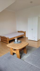 a room with two beds and a wooden table at Ferienwohnung Gästehaus Bauer 2 in Heiligenhaus +9 photos