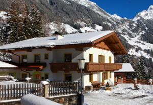 una casa con techo cubierto de nieve en la nieve en Panoramablick Ferienwohnung Schiestl, en Brandberg