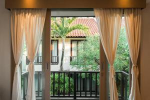 塞米亚克Iryla Villa Bali的带窗帘的窗户和带棕榈树的阳台