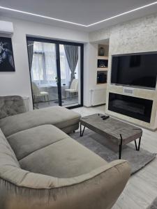 a living room with a couch and a flat screen tv at Dary Luxury Apartment in Turnu Măgurele