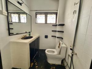 a bathroom with a toilet and a sink and a mirror at Cozy Family Homestay 2BR with Balcony in Shared Bungalow SS2 PJ in Petaling Jaya +27 photos