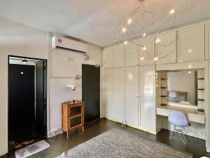 a room with white cabinets and a table and a chair at Cozy Family Homestay 2BR with Balcony in Shared Bungalow SS2 PJ in Petaling Jaya