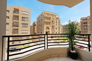 a balcony with a view of some buildings at Travelholic Residence Near Mivida in Cairo