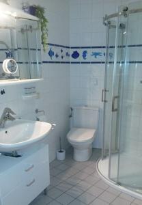Un baño con inodoro, lavabo y ducha. en Aloha, en Julianadorp
