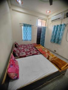 ブリンダーバンにあるShyama Guest House and Apartmentsの青いカーテンが備わる客室のベッド2台